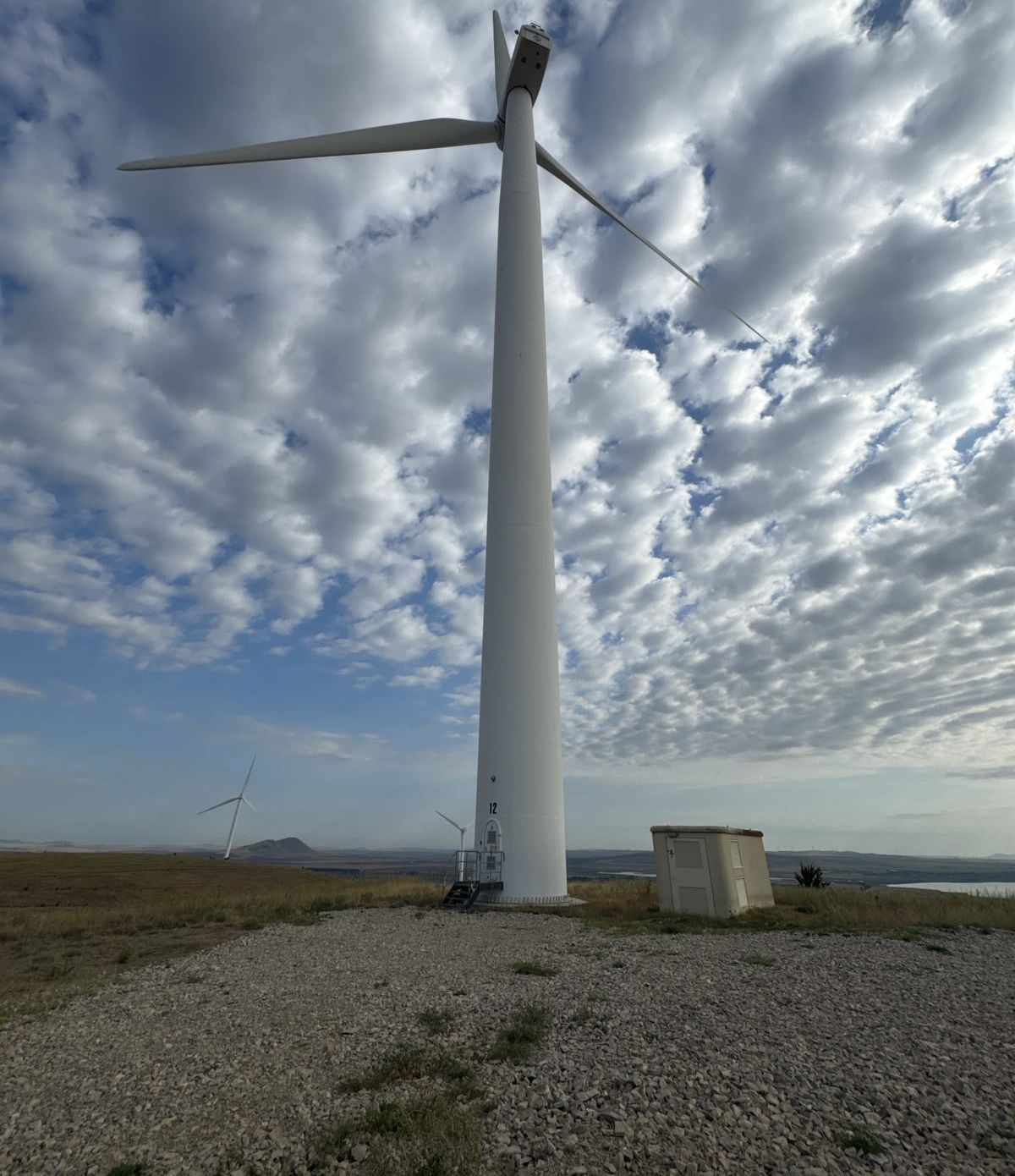 Windenergieanlage in der Totalen vor bewölktem Himmel